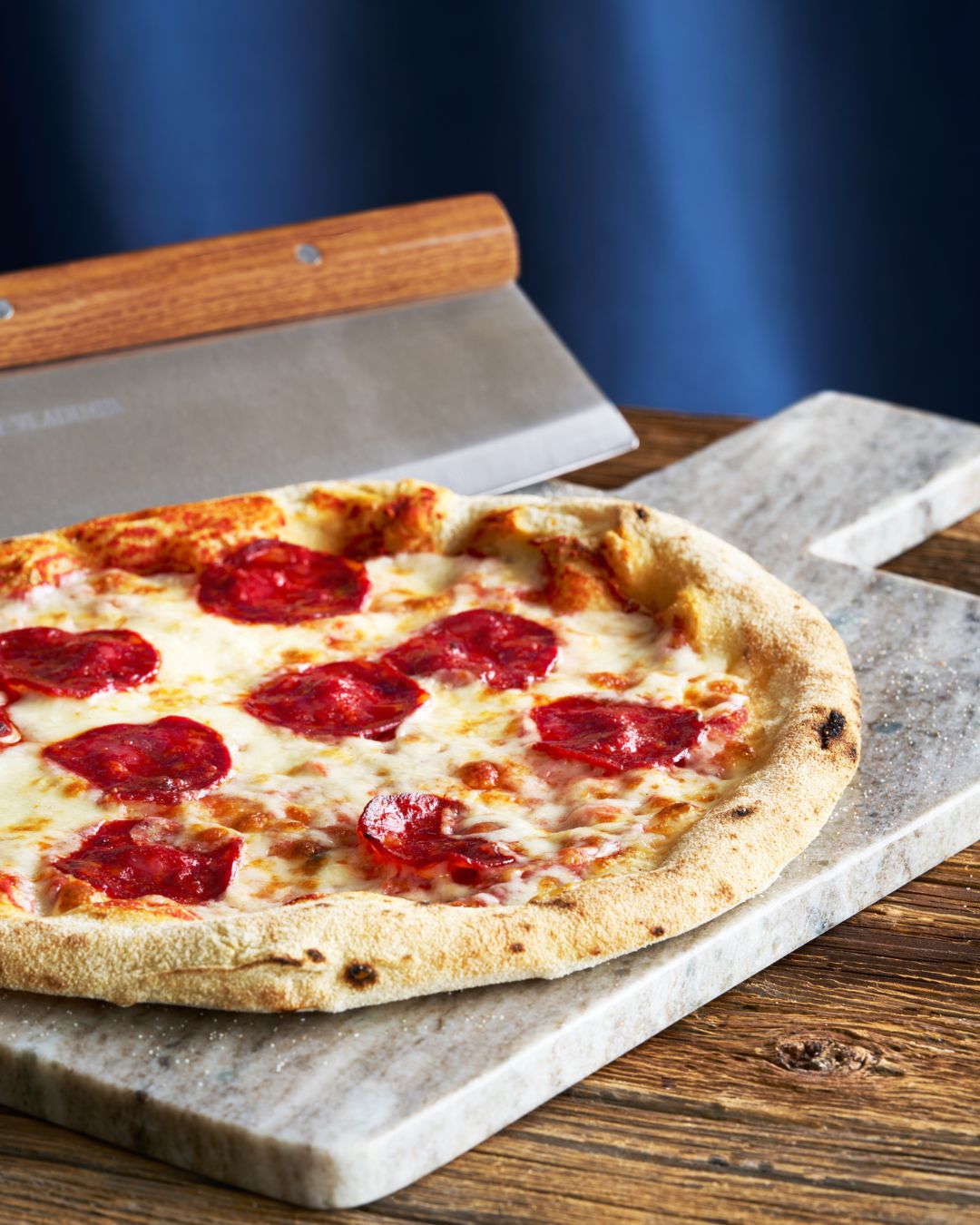 Surdejspizza med mozzarella og chorizo på et skærebræt